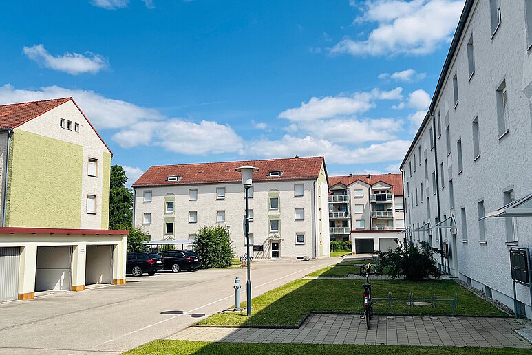 Quartier mit mehreren Mehrfamilienhäusern, dreigeschossig mit Schrägdach, dazwischen Anliegerstraßen und Grünanlagen