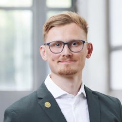 Lennart Feldmann Porträt, Person mit kurzen Haaren und Brille, mit Hemd und Sakko gekleidet