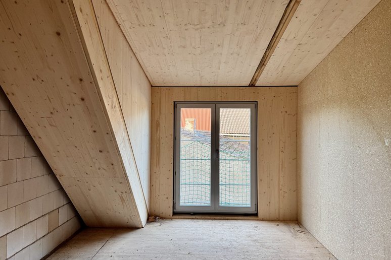 Bild zeigt Zimmer in Holz mit großem Fenster