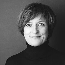 Portraitfoto in Schwarz-Weiß, Person mit kinnlangen Haaren und Rollkragen-Pullover