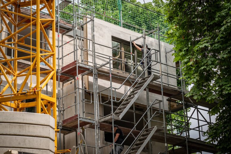 Fassadenelement wird von Bauarbeiter platziert zur Montage am Gebäude.