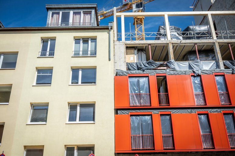 Zwei aneinandergrenzende Wohngebäude, das Gebäude rechtsseitig befindet sich gerade in der Sanierung.