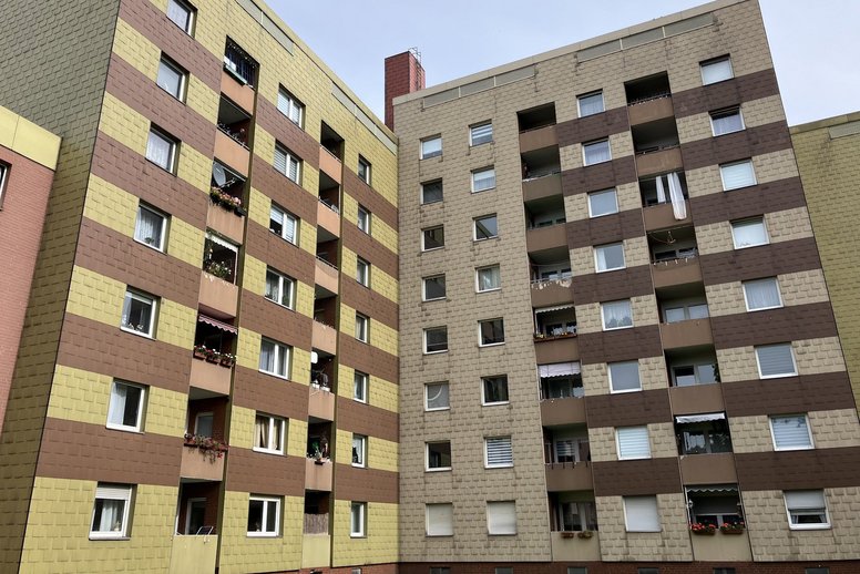 Mehrfamilienhaus mit Fenstern und Balkonen, unsaniert