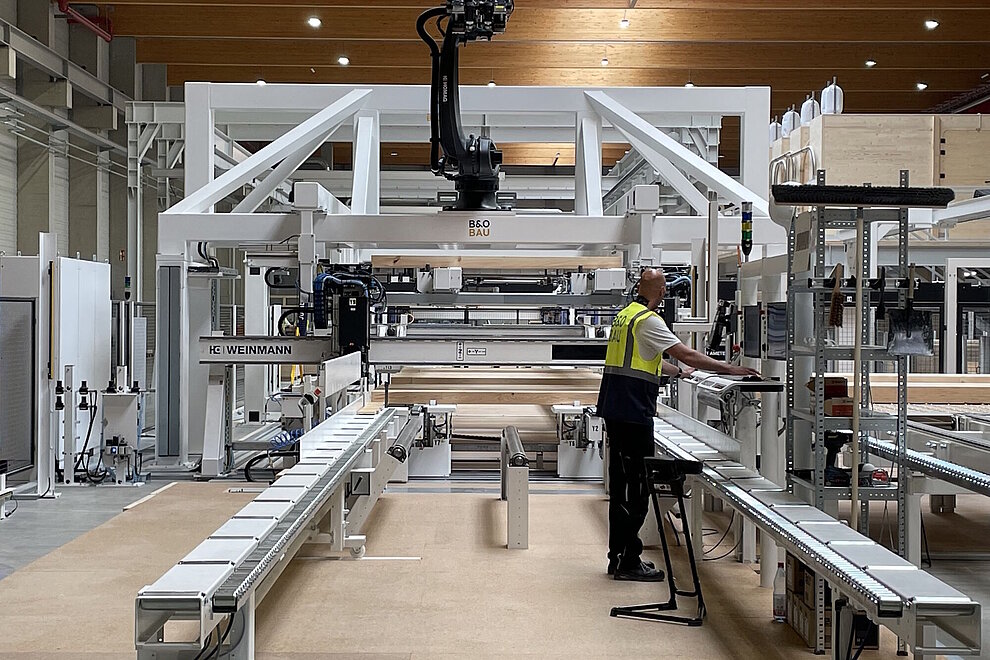 Produktionsanlage in einer Werkhalle und Arbeiter