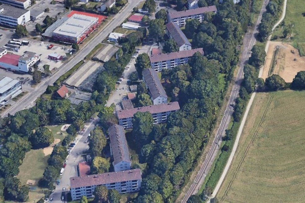 Luftaufnahme Wohnquartier, mehrere Gebäude, Straßen und Grünflächen mit großen Laubbäumen