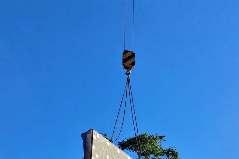 Vorgefertigtes Fassadenelement schwebt an Kran.