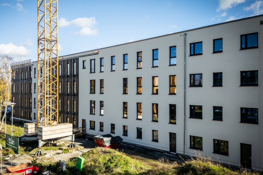 Mehrfamilienhaus viergeschossig während Sanierung, sonniger Himmel