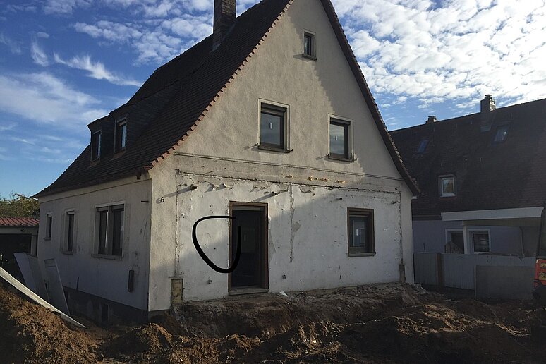 Einfamilienhaus bei der Entkernung mit umgegrabenem Vorgarten