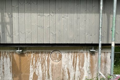 Haussockel, unsanierte Fläche unterhalb des bereits montierten neuen Fassadenelements