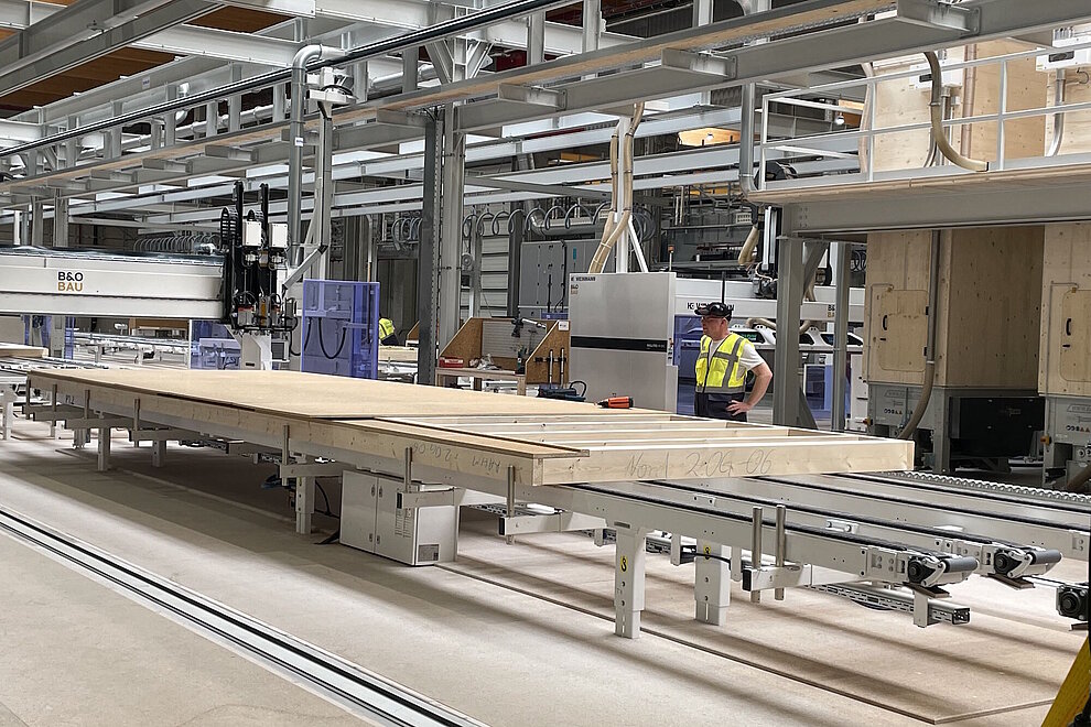 Produktionsanlage in einer Werkhalle und ein Arbeiter
