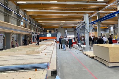 Produktionshalle mit vorgefertigten Fassadenlementen aus Holz, Gäste zur Eröffnung