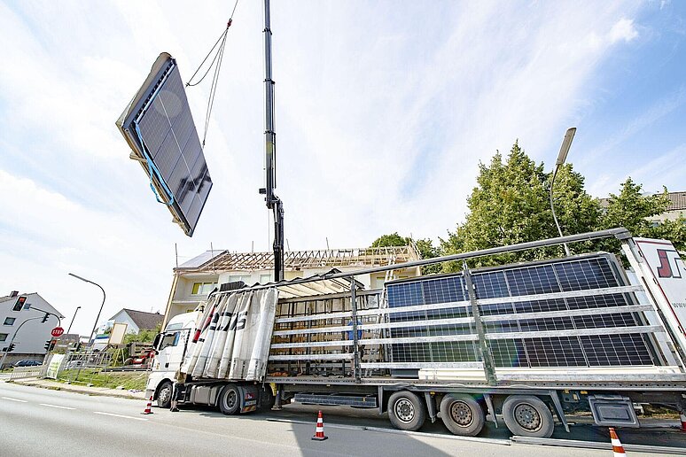 LKW mit Kran und Fassadenelementen