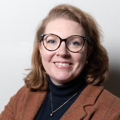 Porträt, Person mit mittellangen Haaren und Brille, Pullover und Blazer