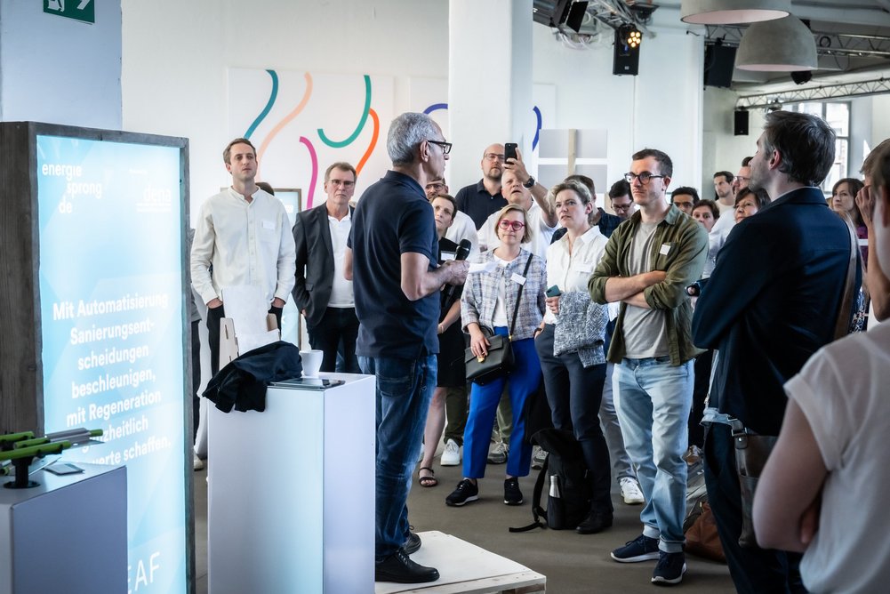 Innovationsmarkt Person spricht zu Personengruppe auf einer Fachveranstaltung.