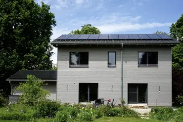 Bild zeigt saniertes Haus mit Vorgarten und Photovoltaikanlage auf dem Dach