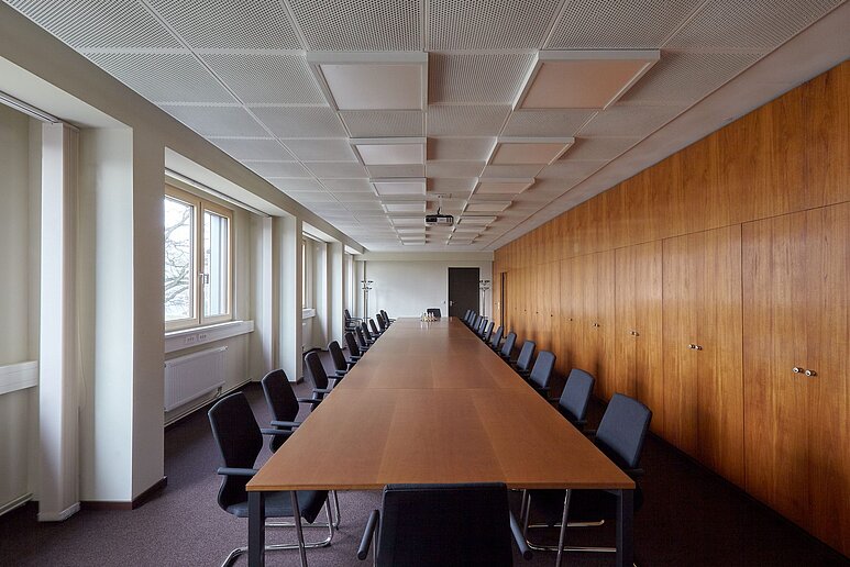 Besprechungsraum mit Tisch und Stühlen, viel Holz