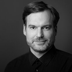 Portraitfoto in Schwarz-Weiß, Person mit kurzen Haaren