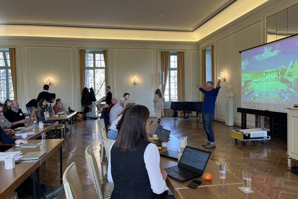 Auftakt der Circular Reno Partner Days im Hauptgebäude der Universität Bonn. Menschen in Ballsaal an Tischen vor Präsentationswand