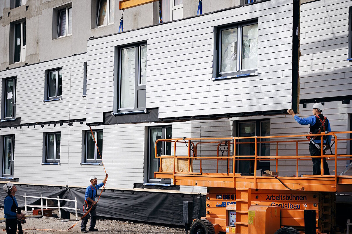 Schwebendes vorgefertigtes Fassadenelement vor Hausfassade