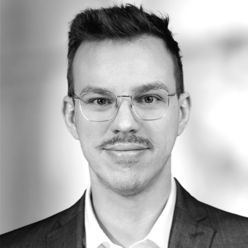 David Kreulitsch Portraitfoto in Schwarz-Weiß, Person mit kurzen Haaren und Brille