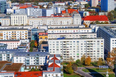 Blick aus der Luft auf einen Wohnkomplex mit mehreren hochgeschossigen Neubauten, darunter auch Plattenbauten