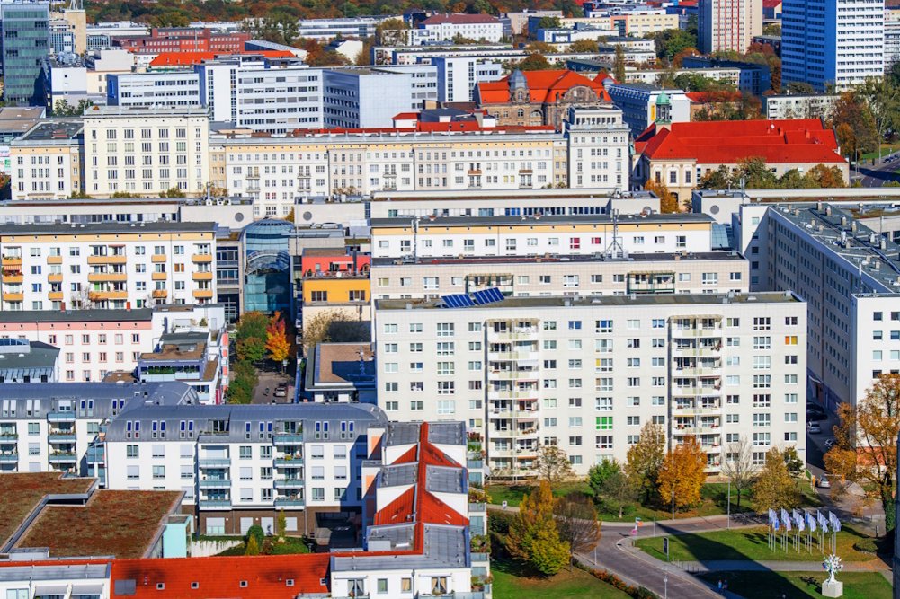 Blick aus der Luft auf einen Wohnkomplex mit mehreren hochgeschossigen Neubauten, darunter auch Plattenbauten
