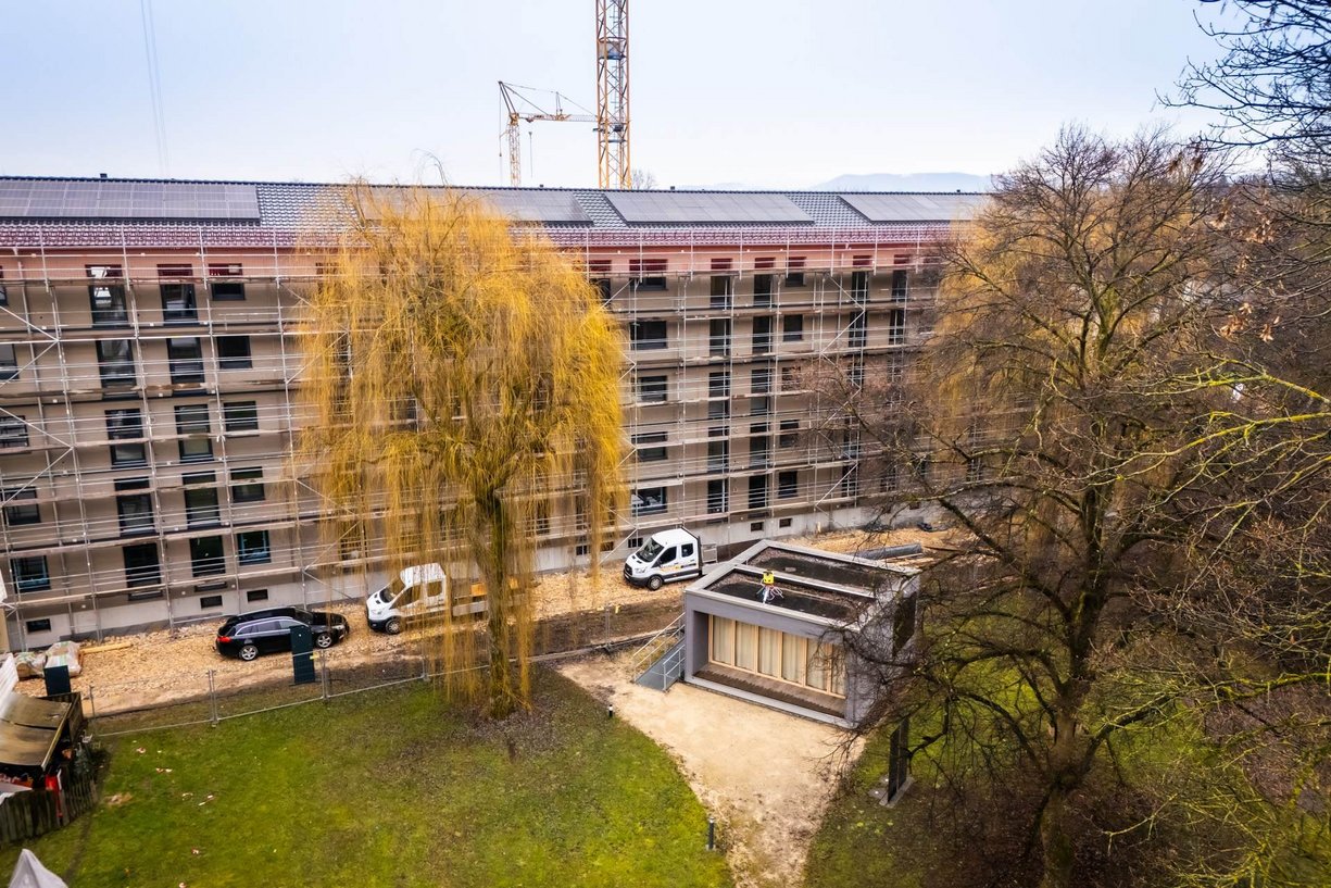 Bild zeigt: Luftaufnahme eines Gebäudes während der seriellen Sanierung, Fokus auf die Fassade