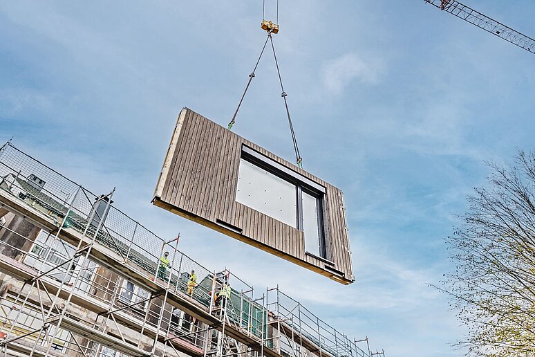 Fliegende Holzfassade vor Baugerüst