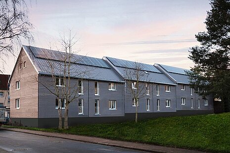 Gebäude vor Straße frisch saniert mit PV