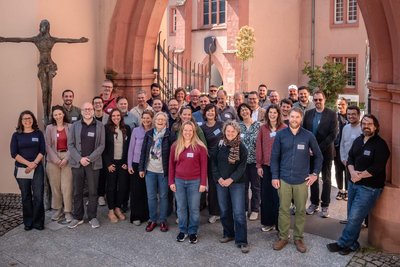 Personengruppe steht unter einem Torbogen für ein Gruppenfoto.