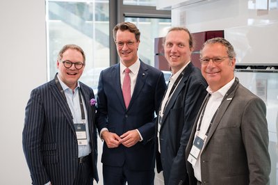 Vier Personen in Anzügen stehen nebeneinander für ein Gruppenbild.