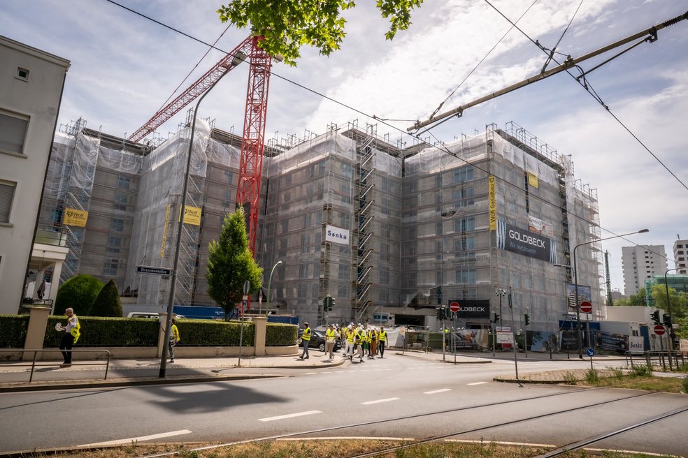 Gebäudekomplex während Sanierung, davor eine Straße