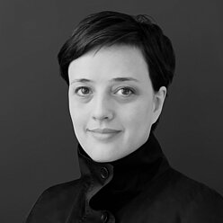Paula Baptista Portraitfoto in Schwarz-Weiß, Person mit kurzen dunklen Haaren
