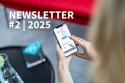 Zwei Hände halten ein Smartphone mit dem Newsletter-Archiv von energiesprong.de auf dem Display; darüber liegt der Schriftzug ‚NEWSLETTER #2 | 2025‘.
