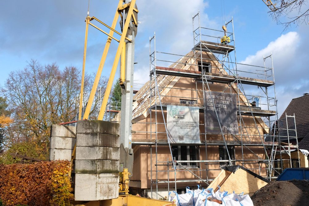 Haus der Familie Nasso in Schlangen während der Sanierung. Haus in Gerüst mit Kran vom Bürgersteig aus