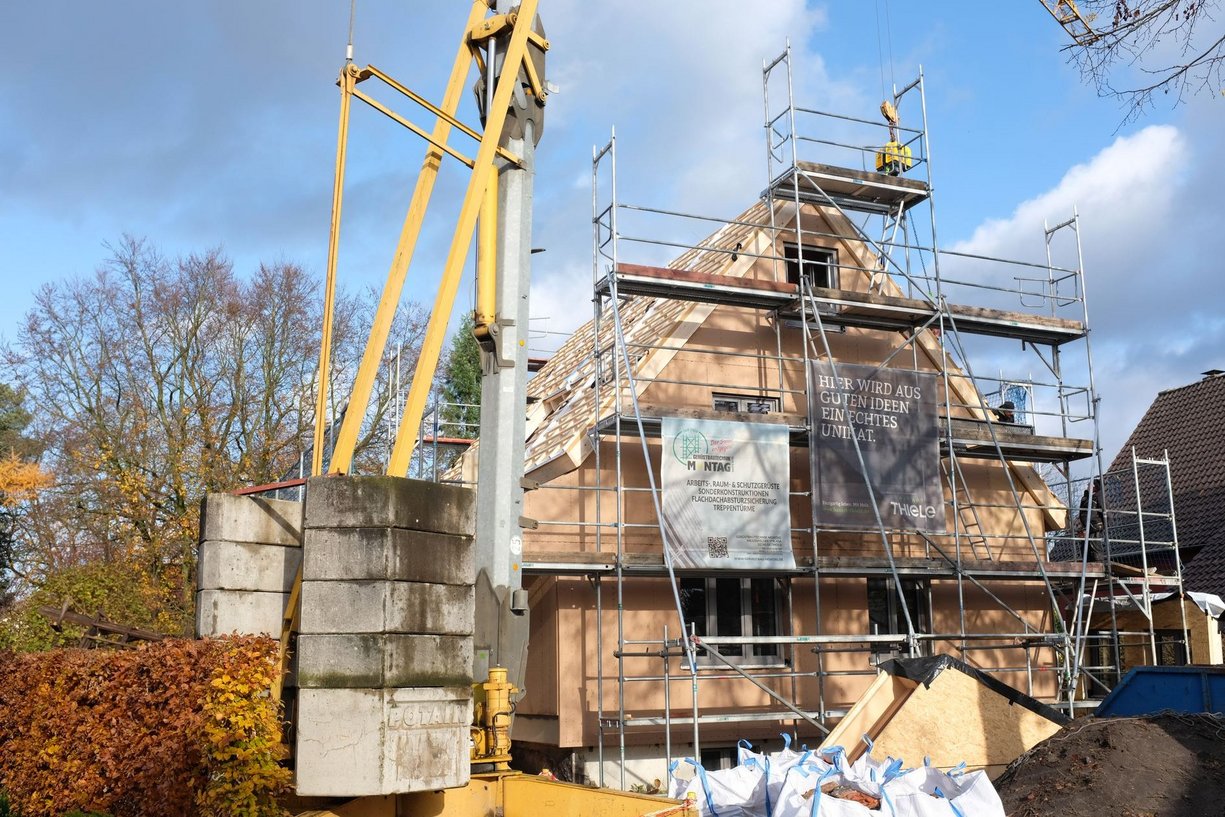 Haus der Familie Nasso in Schlangen während der Sanierung. Haus in Gerüst mit Kran vom Bürgersteig aus