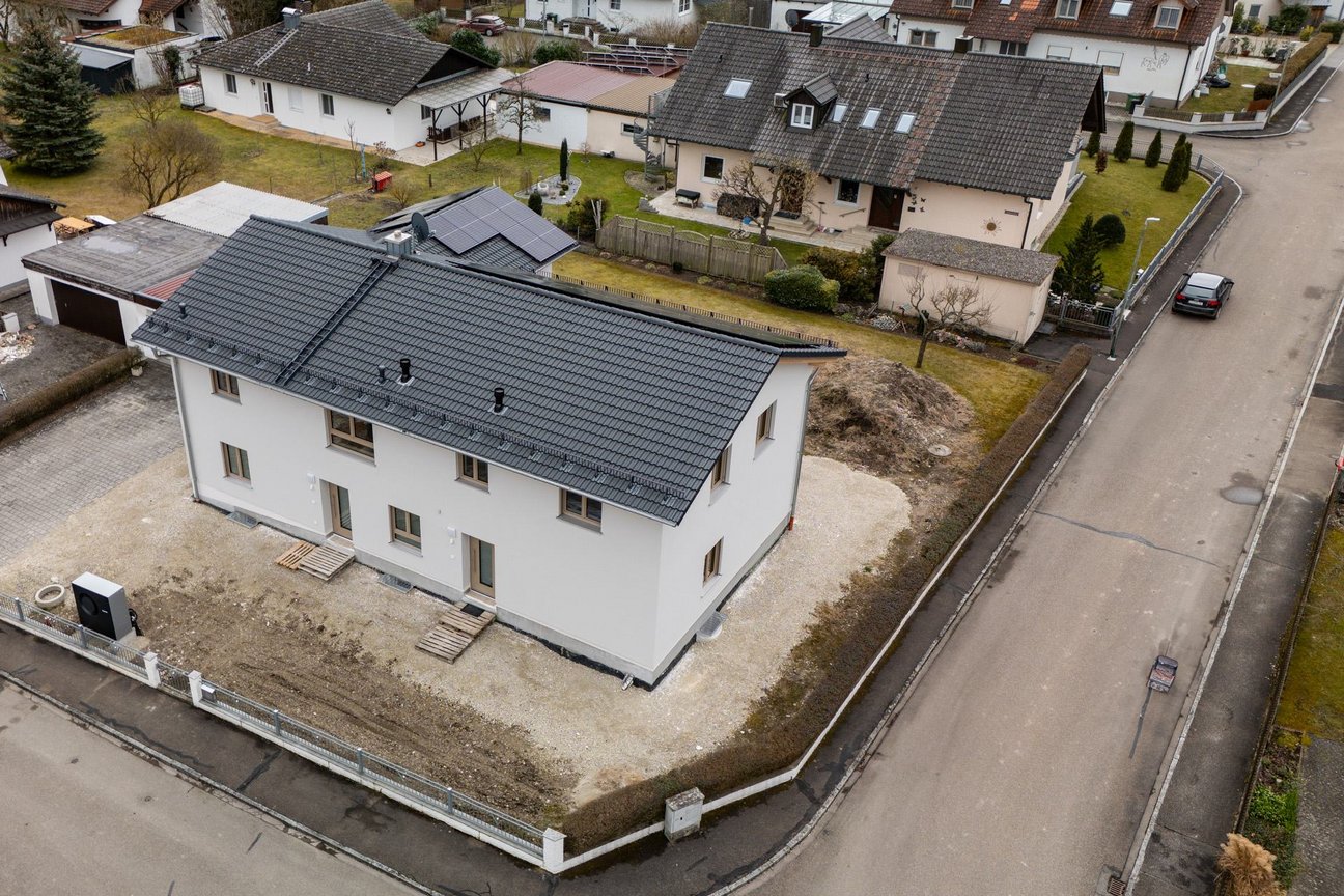 Seriell saniertes Einfamilienhaus in Pförring, Bayern Luftaufnahme eines Hauses mit PV auf dem Dach