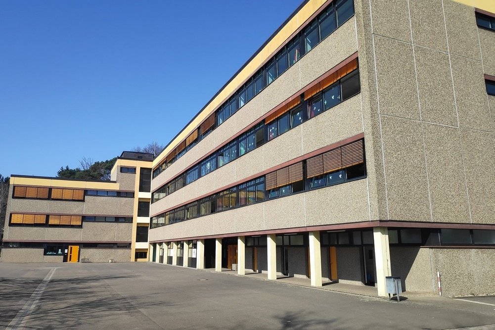 Die Realschule Plus in Ramstein-Miesenbach geht bei der seriellen Sanierung mit gutem Beispiel voran und könnte zur Blaupause für die energetische Modernisierung der rund 47.000 Schulen in Deutschland werden. Schulgebäude mit Schulhof
