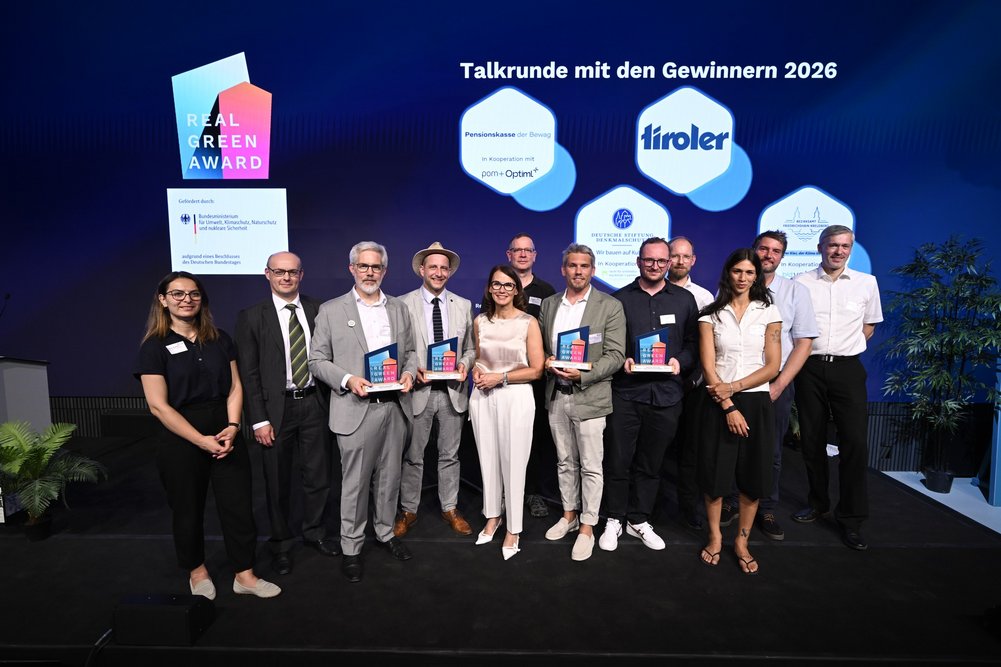Die Preisträger des diesjährigen RealGreen Awards in der Berliner Münze Bild zeigt Gruppe von Menschen auf einer Bühne, teilweise mit Preisen in der Hand