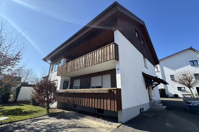 Bild zeigt: Haus mit zwei Stockwerken und Balkonen mit Holzverkleidung