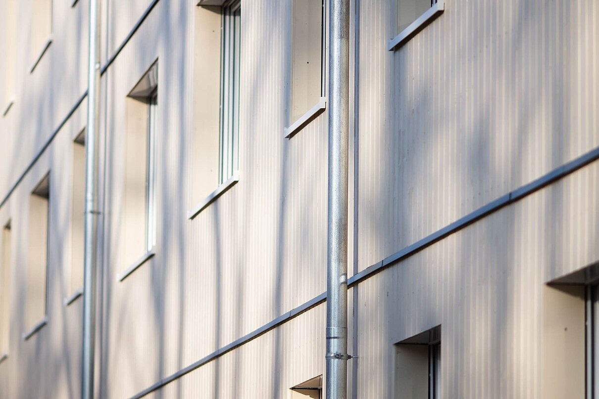 Helle Fassade mit Regenablaufrohr