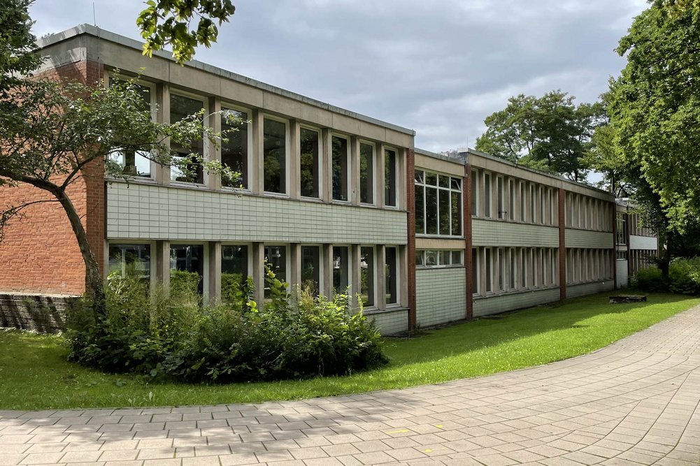 Außenansicht eines zweigeschossigen Schulgebäudes, davor Rasenfläche und Weg
