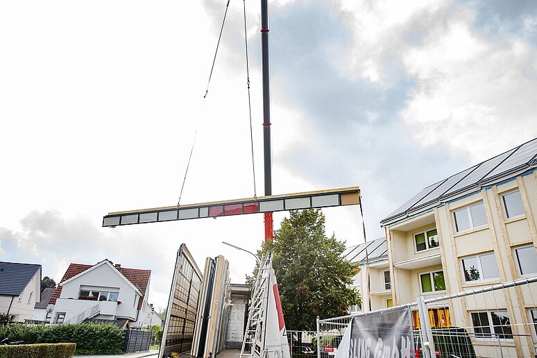 Kran hebt Fassadenteile auf die Baustelle