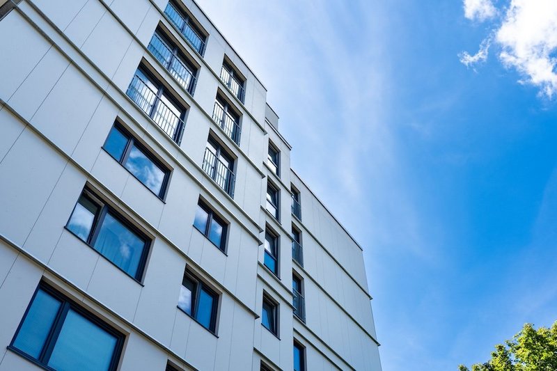 Gebäudefassade mit Fenstern, Blick von unten nach oben zum blauen Himmel