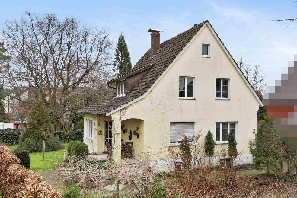 Frontansicht Einfamilienhaus mit Vorgarten und Hecke