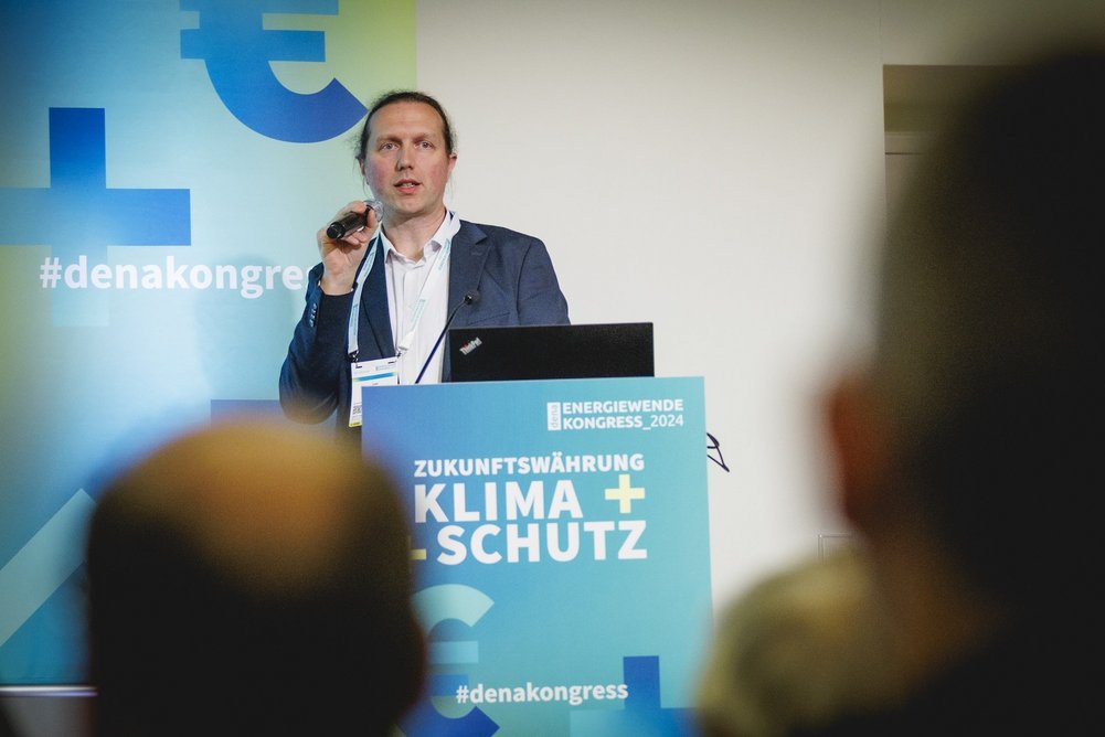 Uwe Bigalke, Leiter des Kompetenzzentrums Serielles Sanieren/ Energiesprong DE der Deutschen Energie-Agentur (dena) Redner am Pult, dena Energiewendekongress