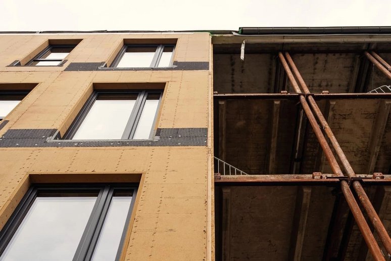 Hausfassade während Sanierung, teils vorgefertigte Fassadenelemente schon montiert