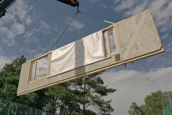 Schwebendes Hausfassadenelement mit Fenster, im Hintergrund leicht bewölkter Himmel und Laubbäume