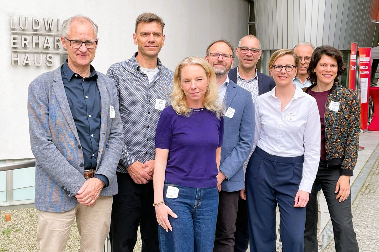 v. l. n. r.: Norbert Illiges (Taskforce Schulbau Berlin), Axel Stab (dena), Inga Stein-Barthelmes (HOWOGE), Timo Sengewald (dena), Jochen Schurr (guteOrte architekten), Anna Rodermund (dena), Roman Koditek (Zimmerei Sieveke), Anke Scheid (dena) Acht Personen stehen nebeneinander für ein Gruppenbild.