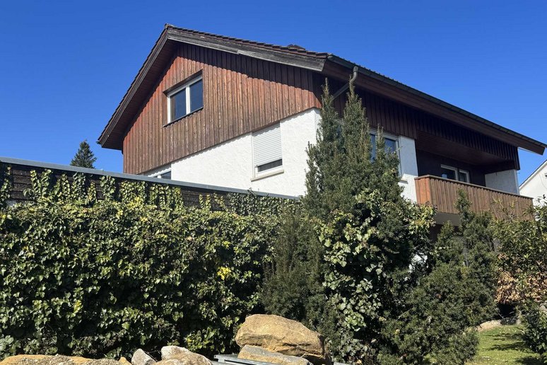 Bild zeigt: Zweifamilienhaus hinter einer Hecke.